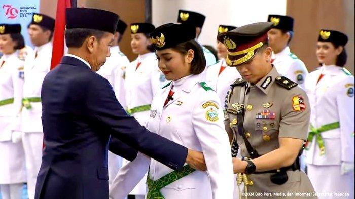 Presiden Joko Widodo (Jokowi) secara simbolis mengukuhkan Paskibraka Nasional 2024 kepada Violetha Agryka Sianturi mewakili rekan-rekannya, di Istana Garuda, Ibu Kota Nusantara (IKN).