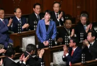 Presiden Partai Demokrat Liberal (LDP) Sanae Takaichi berdiri untuk memberikan penghormatan atas tepuk tangan setelah ia terpilih sebagai perdana menteri baru Jepang selama sidang luar biasa majelis rendah parlemen di Tokyo, Jepang, Selasa (21/10/2025). Dia menjadi perempuan PM pertama Jepang.
