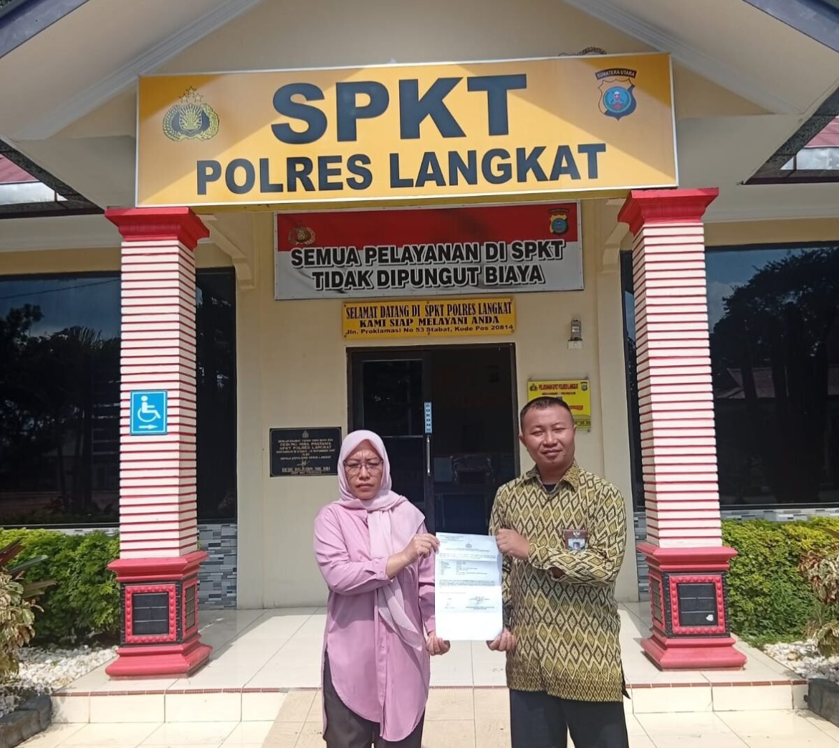 Wirdatul Akmal (kiri) bersama penasehat hukum Adv. Muhammad Hasbi, S.H melaporkan oknum Kades Pasar Rawa ke Polres Langkat, Sabtu (31/1).